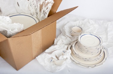 Dishes being packed in wadding. Dishes being packed in wadding.