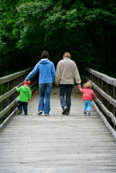 A family walks across a bridge. A family walks across a bridge.