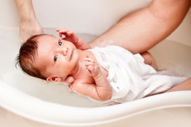 Gentleness describes how this father bathes his baby. Gentleness describes how this father bathes his baby.