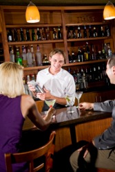 A bartender serves drinks. A bartender serves drinks.