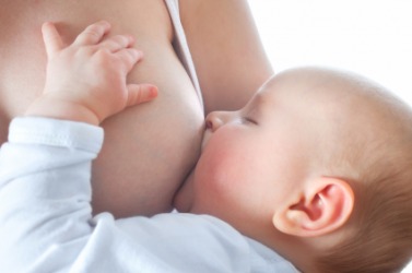 A woman breast feeds her baby. A woman breast feeds her baby.
