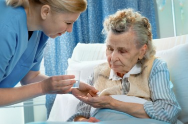 A nurse administers medicine to her patient. A nurse administers medicine to her patient.