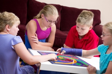 Children interact while playing a board game. Children interact while playing a board game.