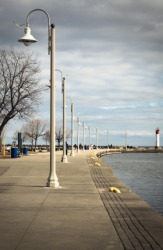 These streetlights are perpendicular to the walkway. These streetlights are perpendicular to the walkway.