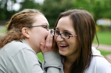 A girl confides a secret to her friend. A girl confides a secret to her friend.