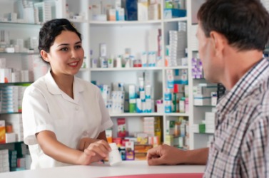 A man receiving medication at a pharmacy. A man receiving medication at a pharmacy.