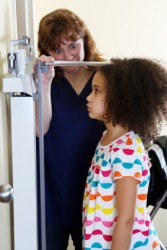 A nurse measures a child's height. A nurse measures a child's height.