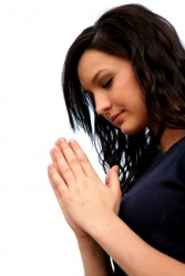 A woman bows her head reverently. A woman bows her head reverently.