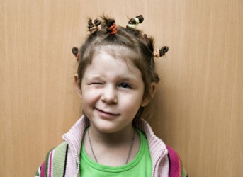 A child gives a funny wink. A child gives a funny wink.