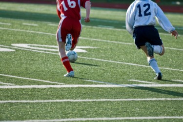 Two players hustle across a soccer field. Two players hustle across a soccer field.