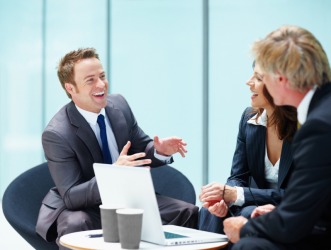 A man tells a funny anecdote to co-workers. A man tells a funny anecdote to co-workers.