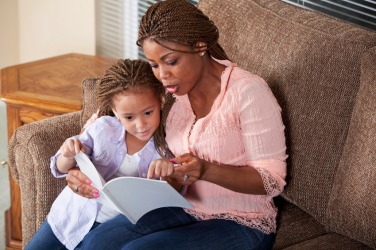 A mother reads aloud to her child. A mother reads aloud to her child.