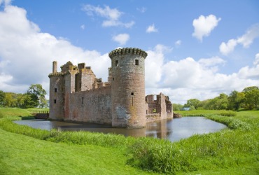 A small castle surrounded by a moat. A small castle surrounded by a moat.