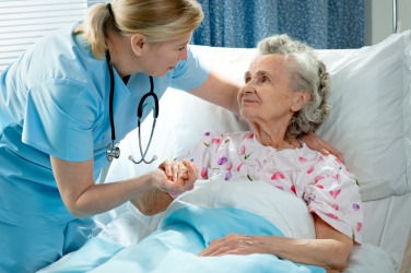 A nurse caring for a patient. A nurse caring for a patient.