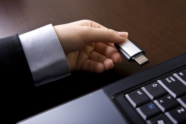 A pen drive being inserted into a USB port. A pen drive being inserted into a USB port.