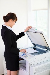 An employee making a copy on a photocopier. An employee making a copy on a photocopier.