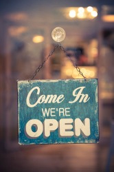 The placard on the front door lets customers know that the store is open for business. The placard on the front door lets customers know that the store is open for business.