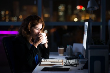 An employee working late playing catch up. An employee working late playing catch up.