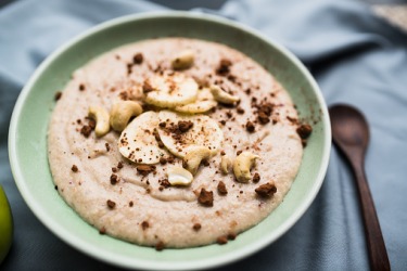 A bowl of porridge topped with bananas and nuts. A bowl of porridge topped with bananas and nuts.