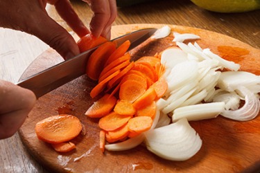 Cutting vegetables in preparation for making soup. Cutting vegetables in preparation for making soup.
