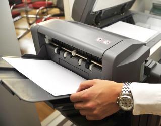 An office employee using a printer. An office employee using a printer.
