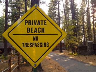 A sign alongside a road indicating a private beach. A sign alongside a road indicating a private beach.
