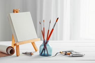 The artist's canvas is propped on the easel. The artist's canvas is propped on the easel.