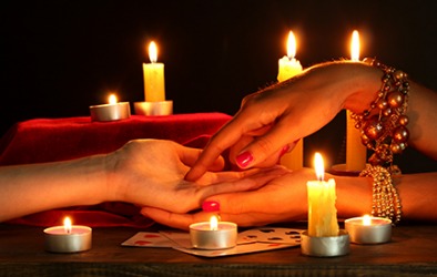 A woman getting a palm reading by a psychic. A woman getting a palm reading by a psychic.
