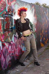 A stylish punker standing against a graffiti wall. A stylish punker standing against a graffiti wall.