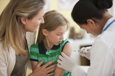 Allie's mom reassured her as she received a vaccination from the nurse. Allie's mom reassured her as she received a vaccination from the nurse.