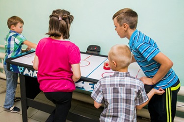 The only sounds in the room are the hum of the air hockey table and the back and forth clack of the puck. The only sounds in the room are the hum of the air hockey table and the back and forth clack of the puck.