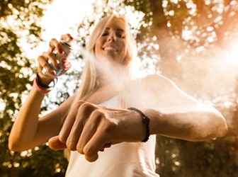Tammie applies bug spray to repel mosquitos before she goes for a hike on the trail. Tammie applies bug spray to repel mosquitos before she goes for a hike on the trail.