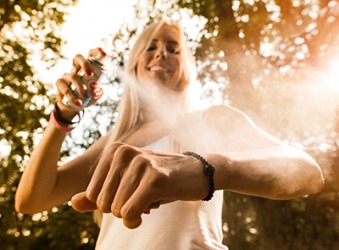 Tammie applies bug repellent to prevent mosquitoes from biting her when she goes for a hike on the trail. Tammie applies bug repellent to prevent mosquitoes from biting her when she goes for a hike on the trail.
