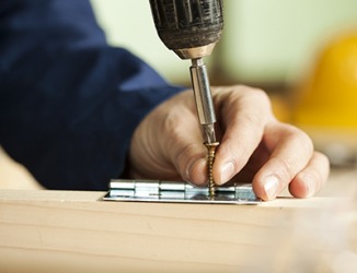 The carpenter attached the hinge to the door with a screw. The carpenter attached the hinge to the door with a screw.