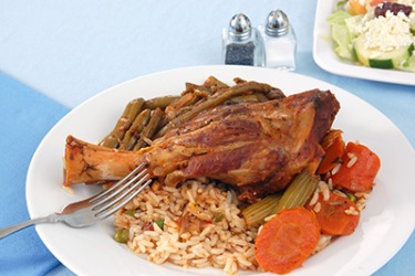 A Greek style roast lamb shank with green beans, carrots and rice pilaf. A Greek style roast lamb shank with green beans, carrots and rice pilaf.