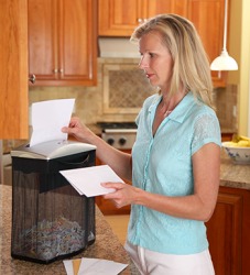Cindy shreds documents in the paper shredder to protect her personal information. Cindy shreds documents in the paper shredder to protect her personal information.