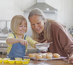 Emily's grandmother showed her how to use a sieve to sprinkle powdered sugar on the cupcakes. Emily's grandmother showed her how to use a sieve to sprinkle powdered sugar on the cupcakes.