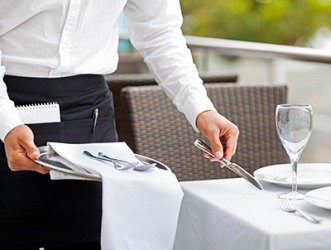 The waiter sets the table with silverware. The waiter sets the table with silverware.