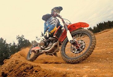 The dirt biker skid as he rounded the sharp turn of the course. The dirt biker skid as he rounded the sharp turn of the course.