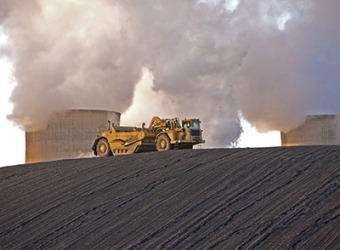 The slagging deposits from a coal fueled power station are discarded into a heap by bulldozers. The slagging deposits from a coal fueled power station are discarded into a heap by bulldozers.