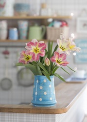 She put the pitcher of flowers over there on the counter. She put the pitcher of flowers over there on the counter.