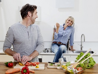 By telling her husband how handsome he looked while cooking, Helen was able to cajole him into making her favorite meal. By telling her husband how handsome he looked while cooking, Helen was able to cajole him into making her favorite meal.