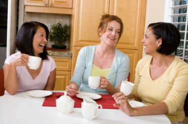 Three women enjoying a good chin-wag over a cup of coffee. Three women enjoying a good chin-wag over a cup of coffee.