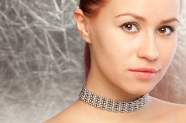 A woman wearing a pearl choker. A woman wearing a pearl choker.