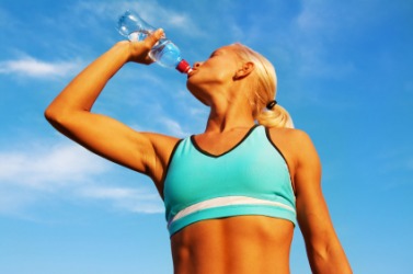 A young athlete chug-a-lugging some water. A young athlete chug-a-lugging some water.