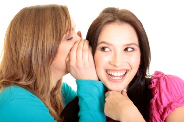 A woman sharing a secret with her chum. A woman sharing a secret with her chum.