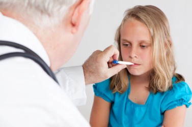 A doctor checking a little girls temperature using a clinical thermometer. A doctor checking a little girls temperature using a clinical thermometer.