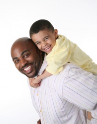A little boy rides on the back of his daddy. A little boy rides on the back of his daddy.