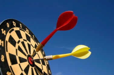 Two darts stuck in a dartboard. Two darts stuck in a dartboard.