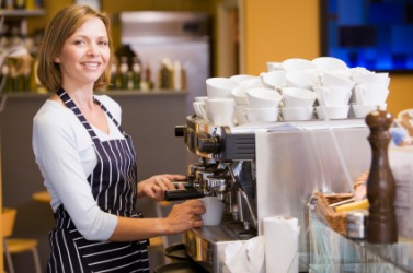 A woman working in a coffeehouse. A woman working in a coffeehouse.